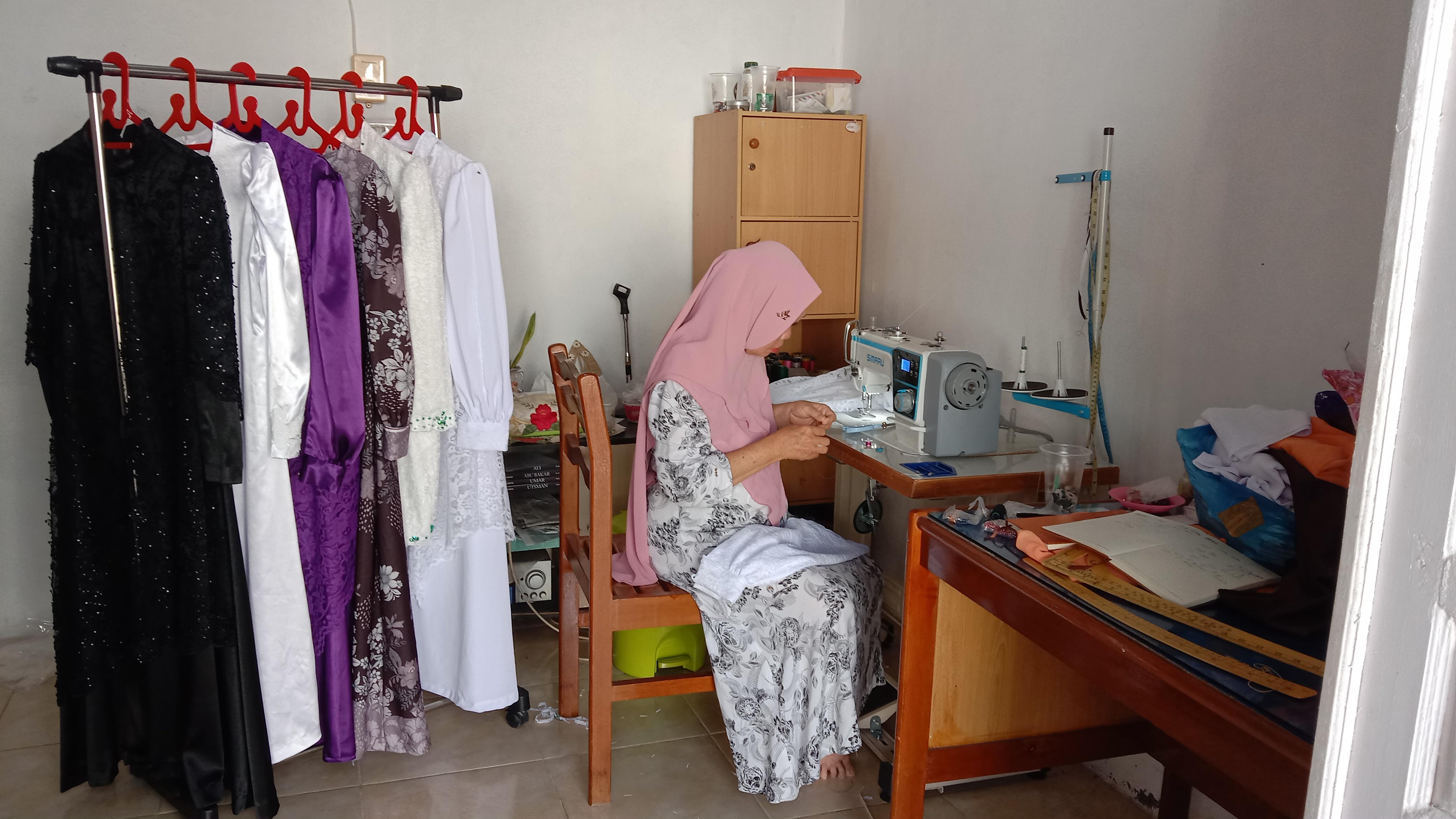 Bu Nurasiah sedang menjahit di workshop